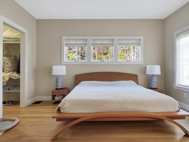 bedroom with wood finished floors and baseboards