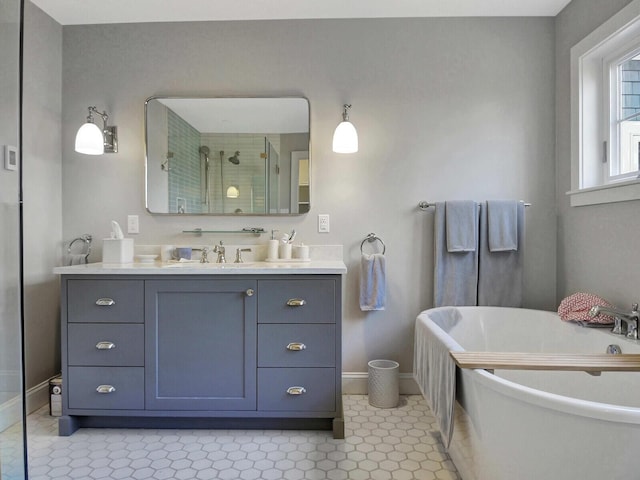 full bath featuring baseboards, a stall shower, vanity, a freestanding tub, and tile patterned floors