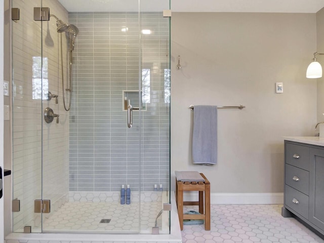 bathroom featuring baseboards, a shower stall, tile patterned floors, and vanity