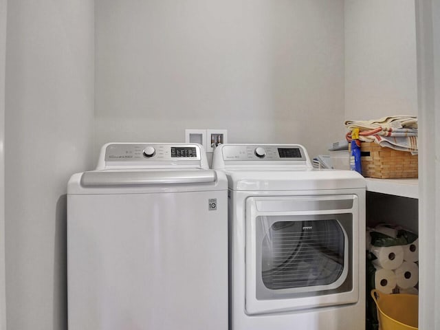 clothes washing area with washer and clothes dryer