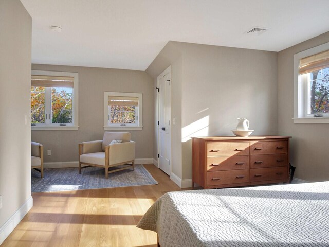bedroom with light wood finished floors and baseboards