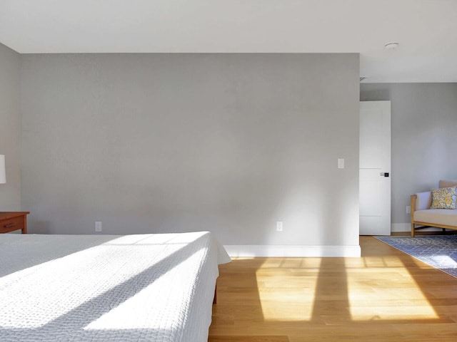 unfurnished bedroom with wood finished floors and baseboards