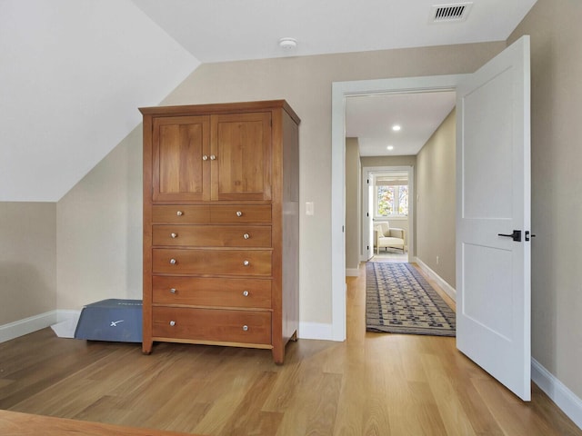 additional living space with light wood-style floors, baseboards, and lofted ceiling