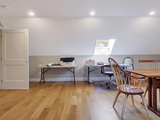 office space with a skylight, wood finished floors, baseboards, recessed lighting, and lofted ceiling