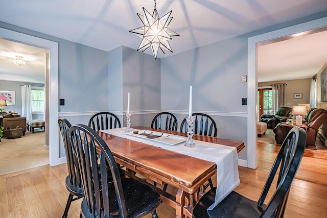 55 Evergreen Ln, Windham, ME 04062 - dining area featuring light wood-style floors, a chandelier, and a wainscoted wall