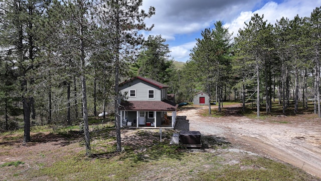 53 Branch Brook Ln, Newfield, ME 04095 - view of front of home with covered porch, dirt driveway, and a view of trees