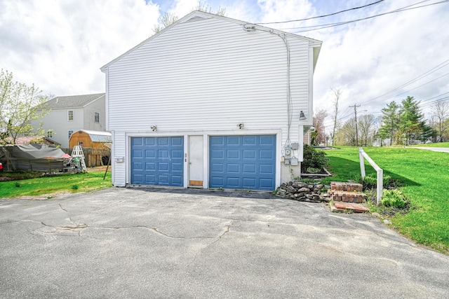 view of property exterior with a garage, a lawn, and driveway