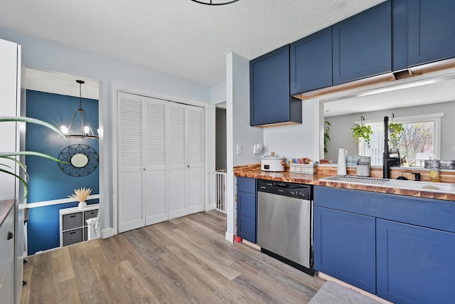 kitchen featuring stainless steel dishwasher, blue cabinetry, light wood finished floors, a sink, and a chandelier