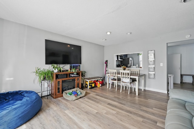 living area with wood finished floors and baseboard heating