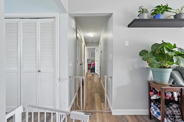 corridor with wood finished floors and baseboards