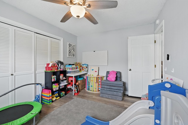 recreation room with wood finished floors and a ceiling fan