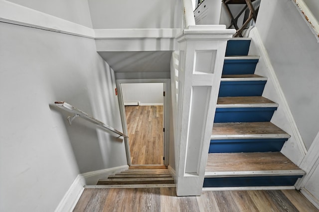 stairs featuring wood finished floors and baseboards