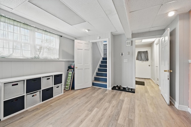 playroom with a paneled ceiling, light wood-style floors, and baseboards