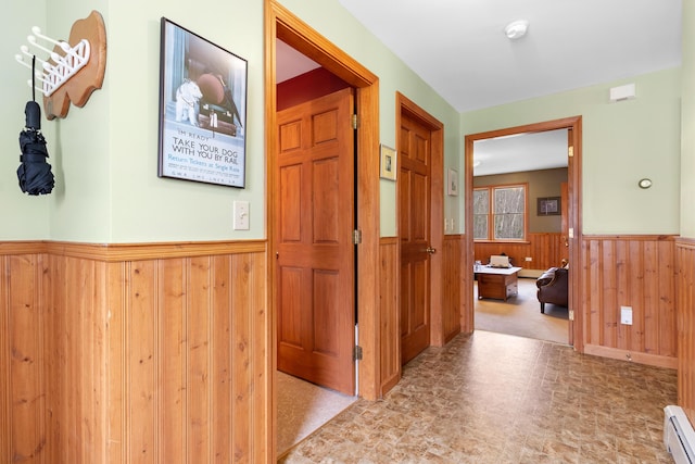 289 W Washington Rd, Washington, ME 04574 - hallway featuring a wainscoted wall, wood walls, and a baseboard radiator