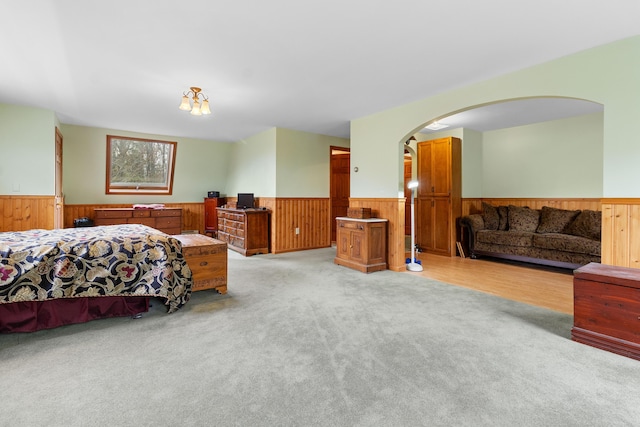 289 W Washington Rd, Washington, ME 04574 - bedroom featuring wainscoting, light colored carpet, arched walkways, and wooden walls
