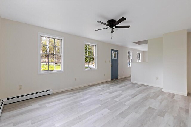empty room with ceiling fan, light wood-style flooring, a baseboard radiator, and baseboards