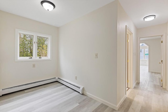 empty room featuring healthy amount of natural light, light wood-style floors, and baseboards