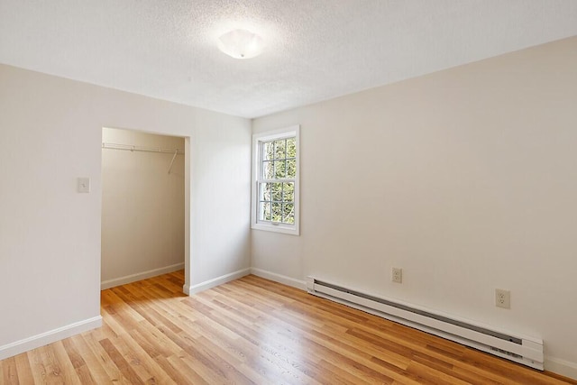 unfurnished bedroom with a baseboard radiator, light wood finished floors, a closet, baseboards, and a textured ceiling