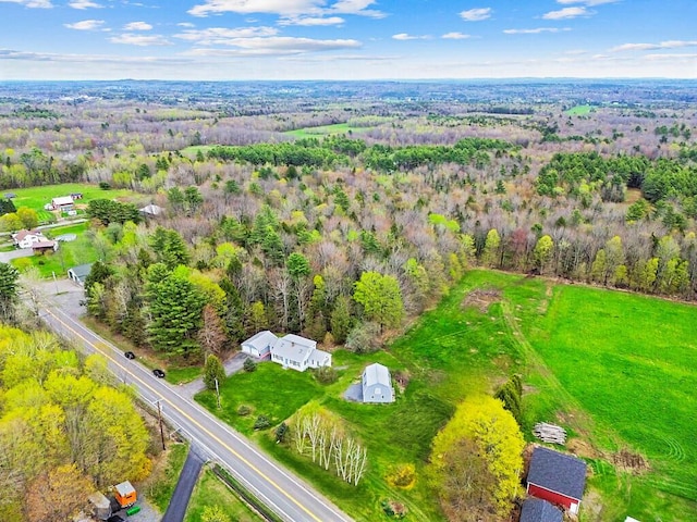 aerial view of property and surrounding area with a heavily wooded area