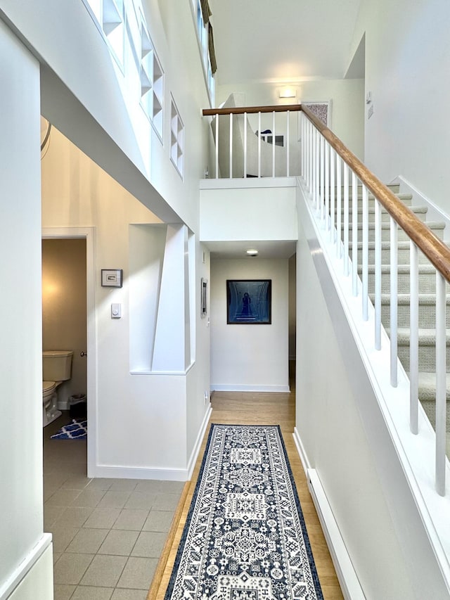 54 Village Way Unit 54, Rockport, ME 04856 - staircase featuring baseboards, a towering ceiling, and tile patterned floors