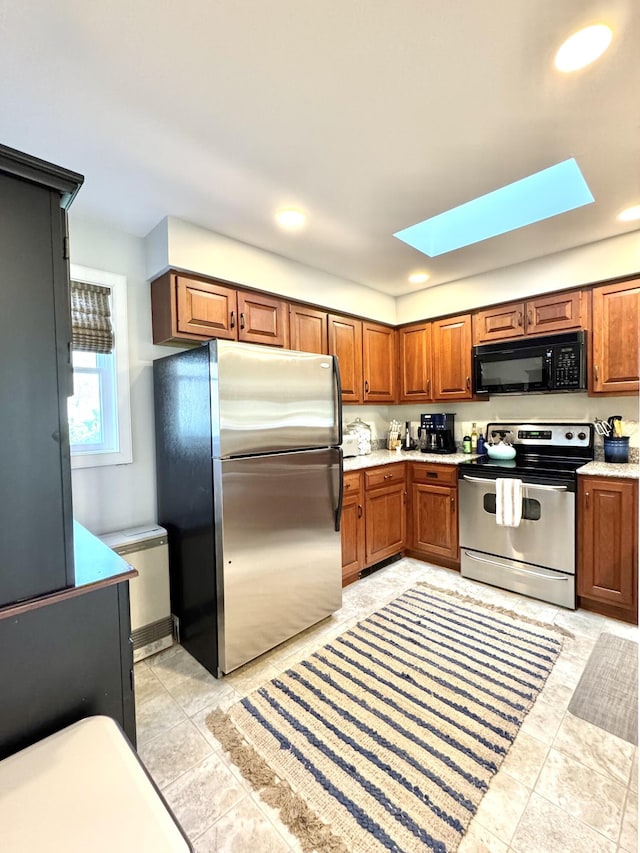 54 Village Way Unit 54, Rockport, ME 04856 - kitchen featuring appliances with stainless steel finishes, a skylight, brown cabinetry, light countertops, and recessed lighting