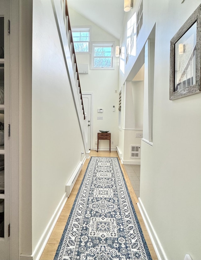 54 Village Way Unit 54, Rockport, ME 04856 - hall with light wood finished floors, stairway, baseboards, and high vaulted ceiling