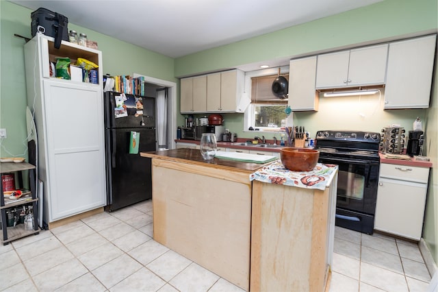 kitchen featuring black appliances, a sink, a kitchen island, and light tile patterned flooring