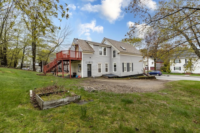 back of property featuring a deck, stairway, a lawn, and roof with shingles