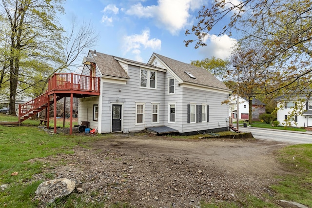 rear view of property featuring a wooden deck, stairway, and roof with shingles
