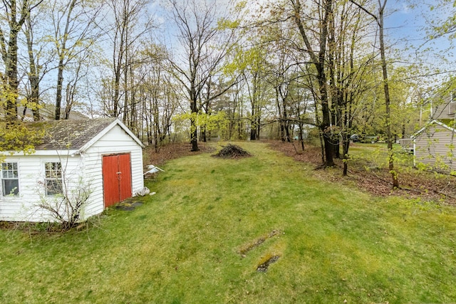 view of grassy yard with a shed and an outbuilding
