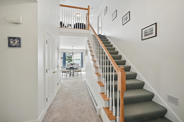 20 Eagle Point Rd, Bath, ME 04530 - stairway with a baseboard heating unit, carpet flooring, a chandelier, a towering ceiling, and baseboards