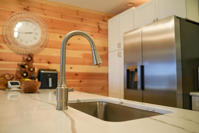 50 Beans Mill Rd, Corinth, ME 04427 - kitchen view of stainless steel fridge, light stone countertops, white cabinets, wooden walls, and a sink