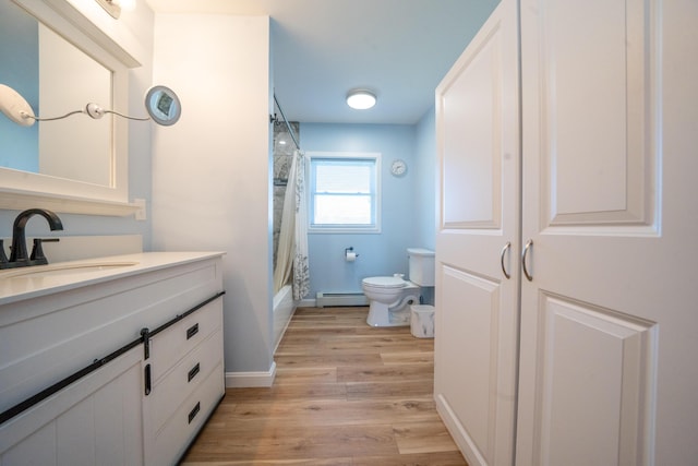 50 Beans Mill Rd, Corinth, ME 04427 - full bath with a baseboard heating unit, toilet, wood finished floors, vanity, and shower / bathtub combination with curtain