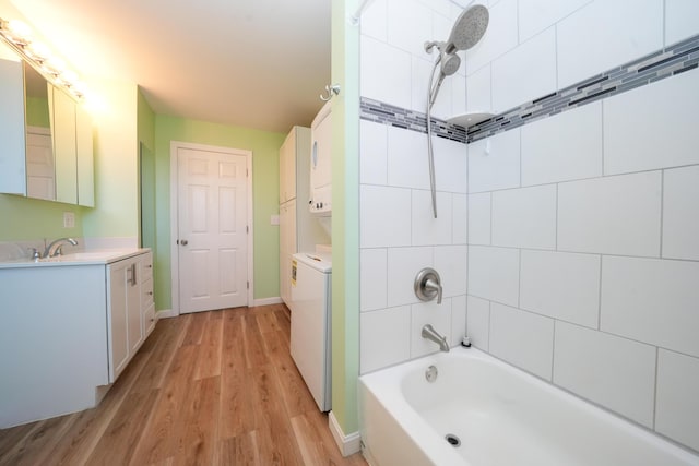 50 Beans Mill Rd, Corinth, ME 04427 - full bathroom with stacked washing machine and dryer, wood finished floors, shower / washtub combination, vanity, and baseboards