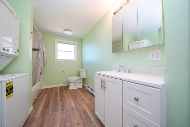 50 Beans Mill Rd, Corinth, ME 04427 - bathroom with stacked washer / dryer, toilet, wood finished floors, a baseboard heating unit, and vanity