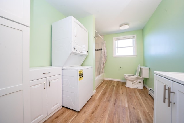 50 Beans Mill Rd, Corinth, ME 04427 - laundry area featuring stacked washing machine and dryer, a baseboard radiator, light wood-type flooring, and baseboards