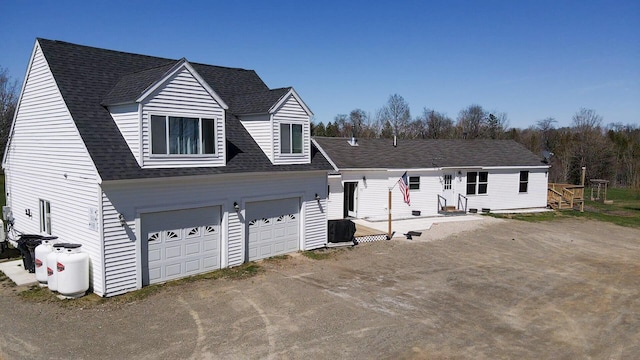 50 Beans Mill Rd, Corinth, ME 04427 - view of front facade with driveway, central AC unit, an attached garage, and a shingled roof