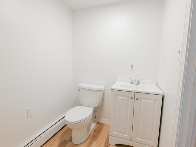 35 Mathews Ave Unit 8, Waterville, ME 04901 - bathroom featuring wood finished floors, baseboard heating, toilet, vanity, and baseboards