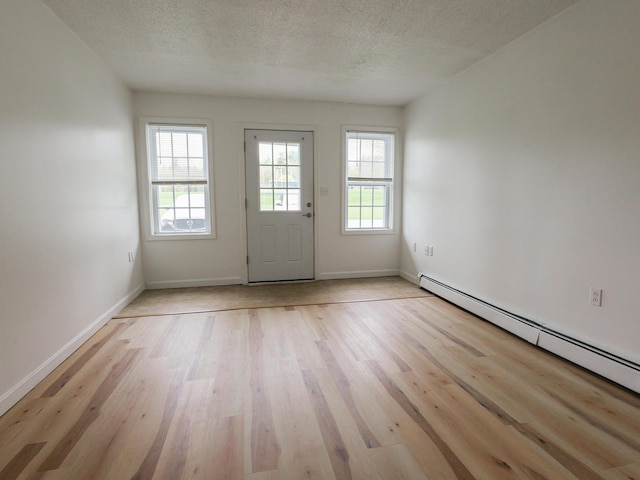 35 Mathews Ave Unit 8, Waterville, ME 04901 - foyer with a baseboard heating unit, light wood-style floors, a textured ceiling, and baseboards