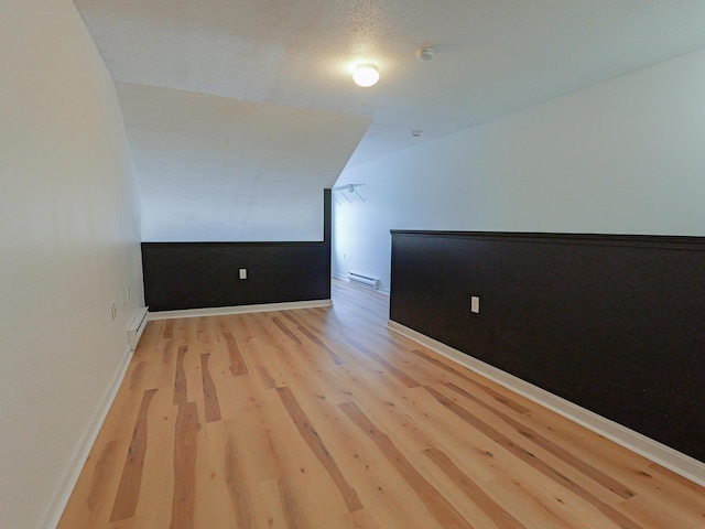 35 Mathews Ave Unit 8, Waterville, ME 04901 - bonus room featuring light wood finished floors, baseboard heating, baseboards, and vaulted ceiling