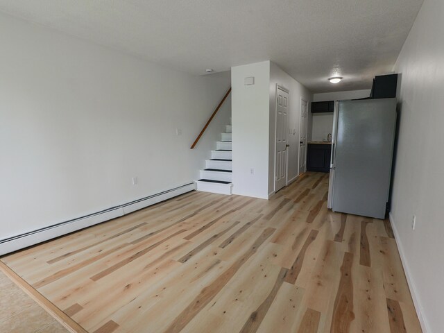 35 Mathews Ave Unit 8, Waterville, ME 04901 - spare room with stairs, light wood-style floors, baseboard heating, and baseboards