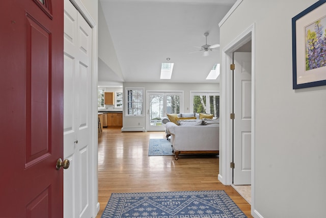 49 Dipper Cove Rd, Harpswell, ME 04066 - entrance foyer with a skylight, light wood-style floors, ceiling fan, a baseboard heating unit, and vaulted ceiling