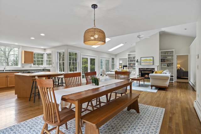 49 Dipper Cove Rd, Harpswell, ME 04066 - dining area featuring ceiling fan, a lit fireplace, recessed lighting, built in features, and light wood-type flooring