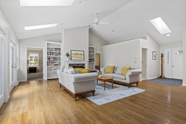 49 Dipper Cove Rd, Harpswell, ME 04066 - living area featuring a skylight, a fireplace, light wood finished floors, built in features, and high vaulted ceiling