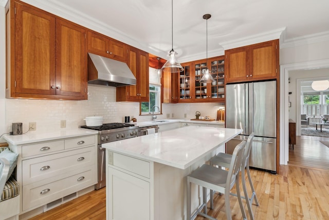 31 Mackworth St, Portland, ME 04103 - kitchen featuring stainless steel appliances, under cabinet range hood, a sink, glass insert cabinets, and tasteful backsplash