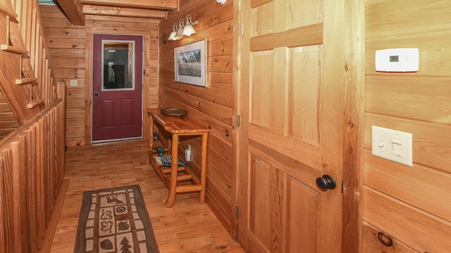 hallway featuring wood walls and light wood-type flooring