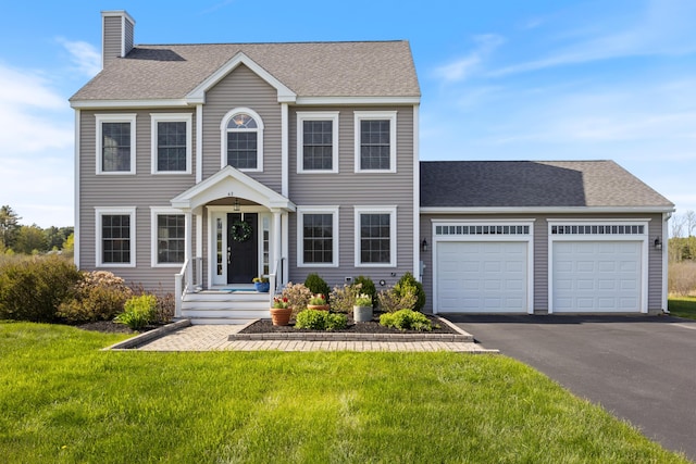 42 Snowberry Dr, Gorham, ME 04038 - colonial-style house with an attached garage, asphalt driveway, a front lawn, a chimney, and a shingled roof