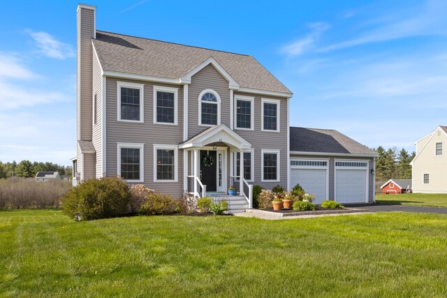 42 Snowberry Dr, Gorham, ME 04038 - colonial-style house featuring an attached garage, asphalt driveway, a chimney, and a front yard