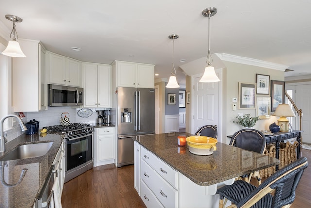 42 Snowberry Dr, Gorham, ME 04038 - kitchen with appliances with stainless steel finishes, a sink, a kitchen bar, decorative backsplash, and crown molding
