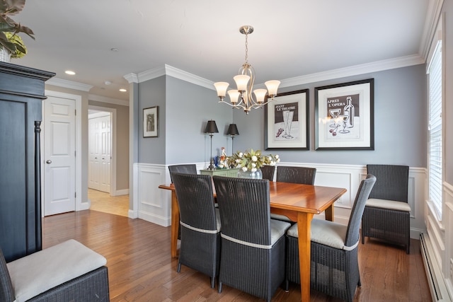 42 Snowberry Dr, Gorham, ME 04038 - dining space featuring a baseboard radiator, a chandelier, crown molding, wood finished floors, and a wainscoted wall